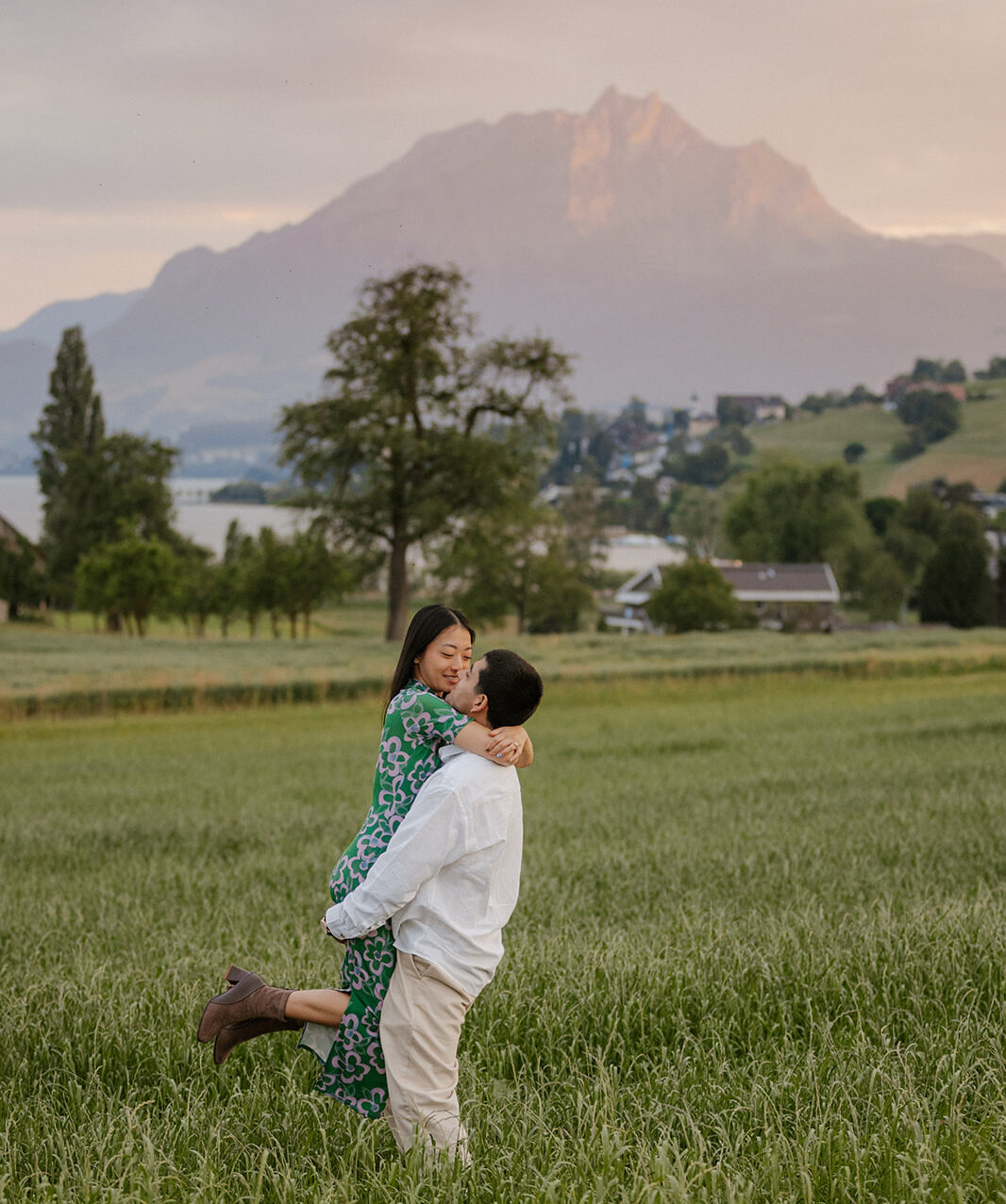 Couple smiling and standing together in a scenic mountain landscape during their engagement photoshoot in Vitznau.